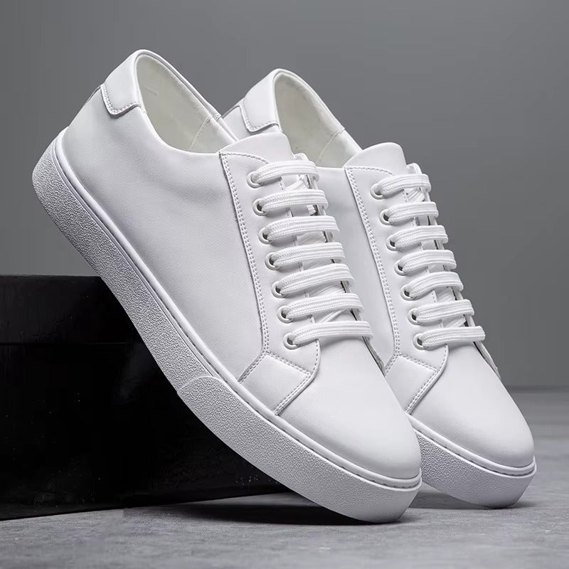 White leather lace-up sneakers for men with flat sole, displayed in pairs against gray background