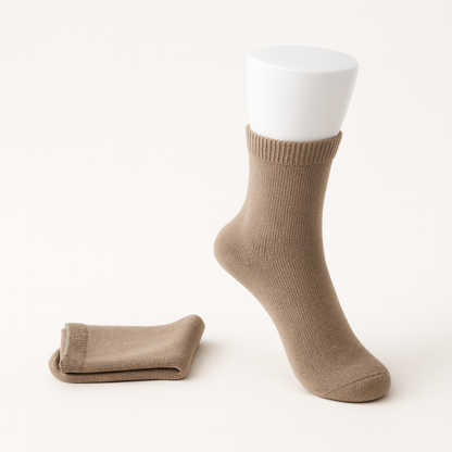 Beige cashmere comfort socks for women displayed on white foot form with folded pair beside it
