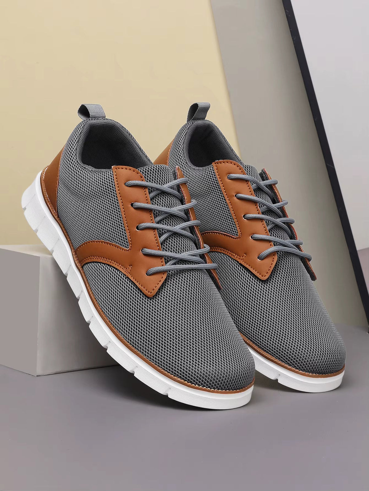 Gray and tan canvas leather orthopedic sneakers with lace-up closure and white cushioned sole, side view.