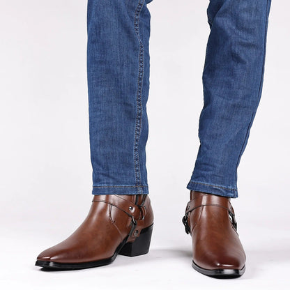 Men's brown leather harness ankle boots with buckle straps and block heel, styled with blue slim-fit jeans.