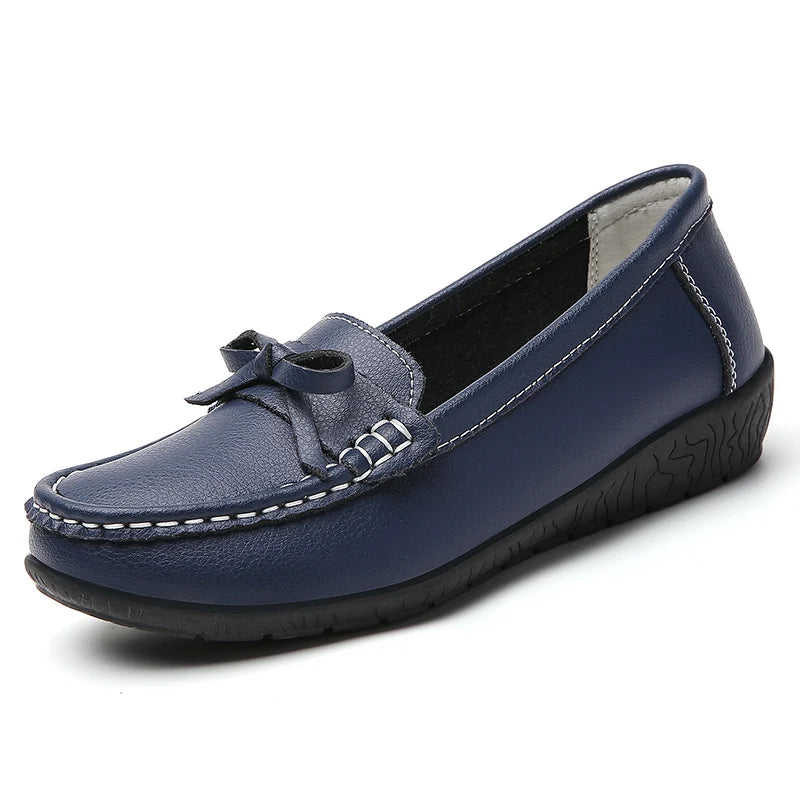 Navy blue women's leather slip-on loafers with decorative bow detail, white stitching, and rubber sole.