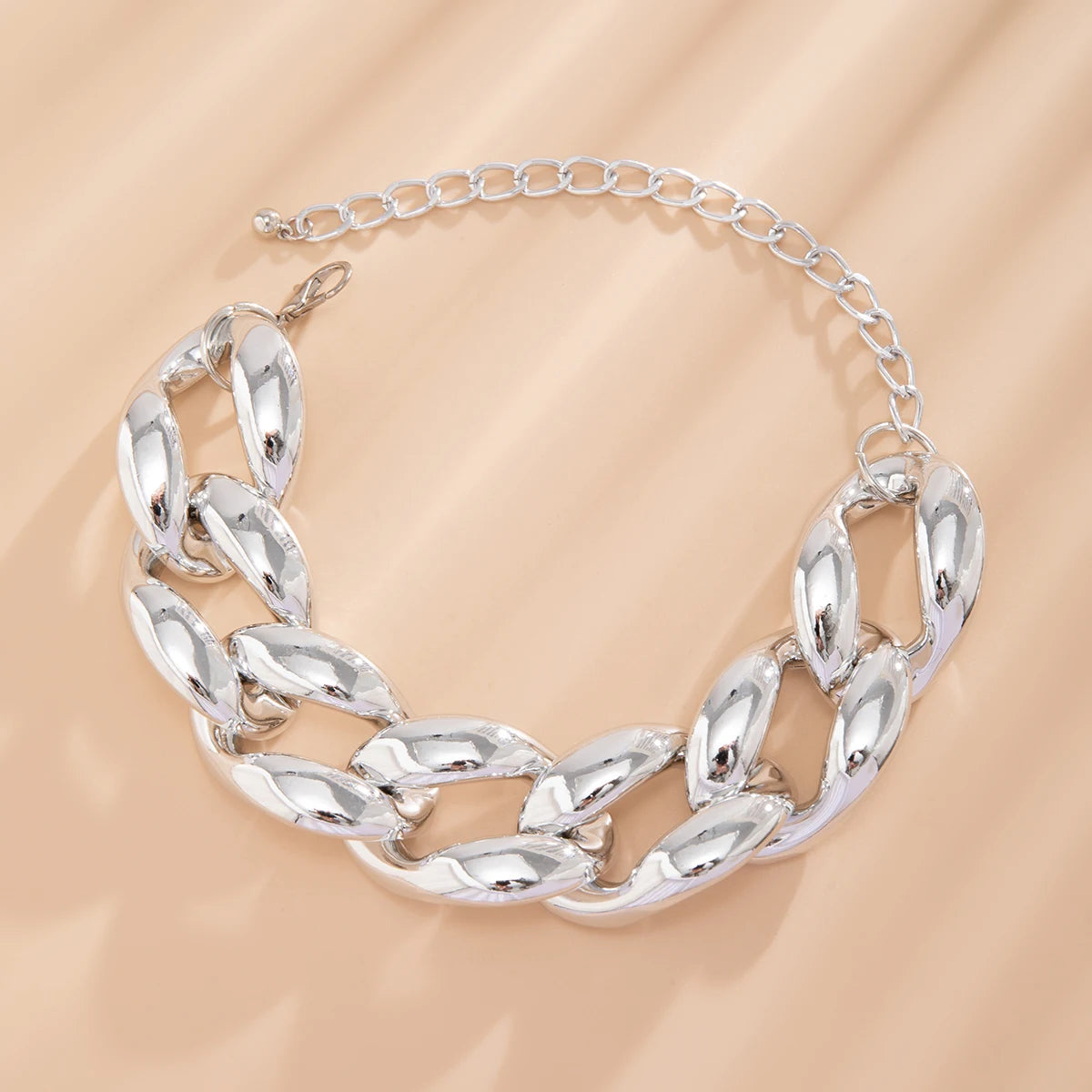 Silver chunky Cuban link chain choker necklace with lobster clasp and adjustable extender chain on beige background