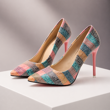 Women's pointed-toe stiletto heels in multicolor patchwork pattern with pink heel, displayed on white platform.