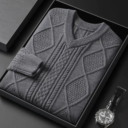 Gray men's cable knit V-neck wool sweater folded in gift box beside a black leather wristwatch