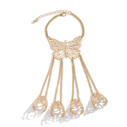 Gold butterfly hand chain bracelet with finger rings, hollow filigree butterfly pendant and tassel chains connecting four finger cuffs