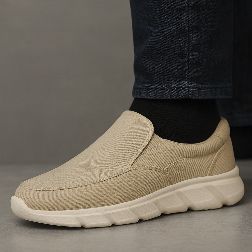 Beige corduroy slip-on sneakers for men with chunky white sole and elastic goring, worn with black jeans