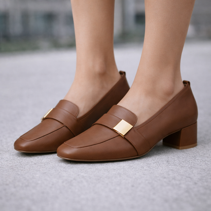 Women's tan leather block heel loafers with gold hardware accent, featuring a classic penny strap and low stacked heel.