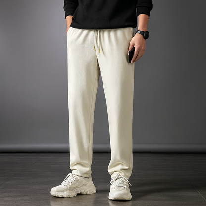 Men's beige ice silk drawstring sweatpants with elastic waist and relaxed fit worn with black sweater and white sneakers