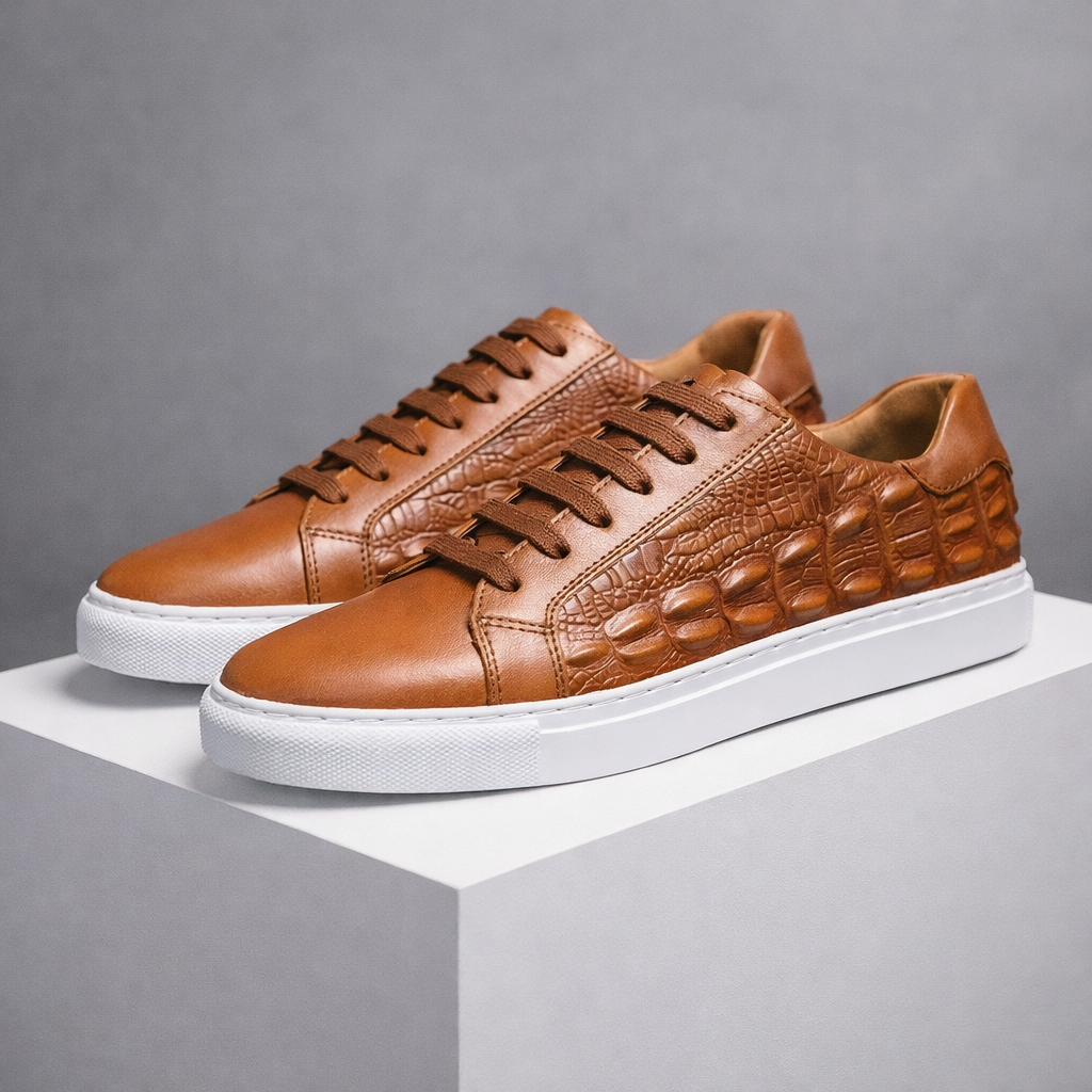 Men's brown leather lace-up sneakers with crocodile embossed texture detail and white rubber sole on display platform