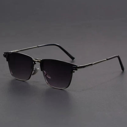 Metal frame polarized sunglasses for men with dark gradient lenses and silver temples on gray background