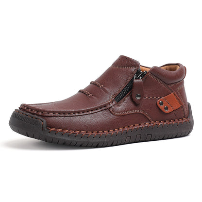 Brown men's leather slip-on ankle boot with side zipper, decorative stitching, and rubber sole.