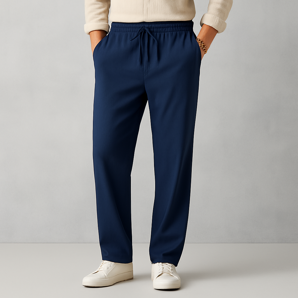 Navy blue men's linen drawstring casual pants with elastic waist, straight leg fit, worn with white sneakers and cream sweater.