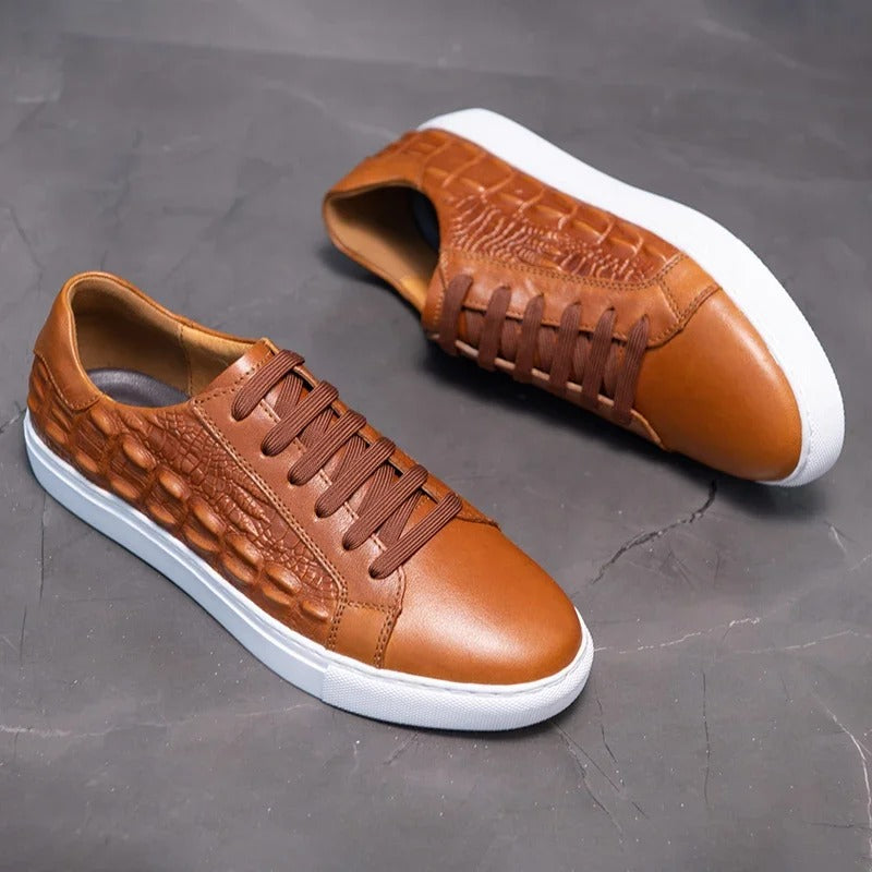 Tan leather men's sneakers with crocodile embossed pattern, brown laces, and white rubber sole, shown from two angles.