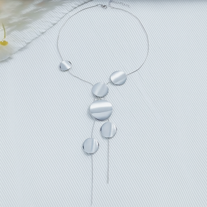 Silver asymmetric disc chain necklace with multiple graduated circular pendants and tassel ends on white background