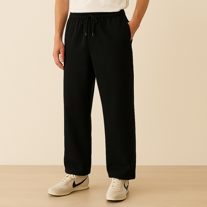 Black cotton drawstring joggers for men with elastic waist and relaxed fit, paired with white sneakers