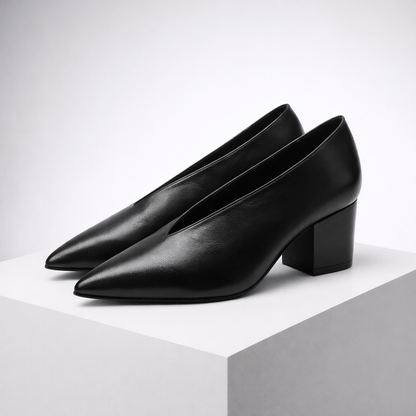 Black Italian leather block heel pumps with pointed toe on white display platform