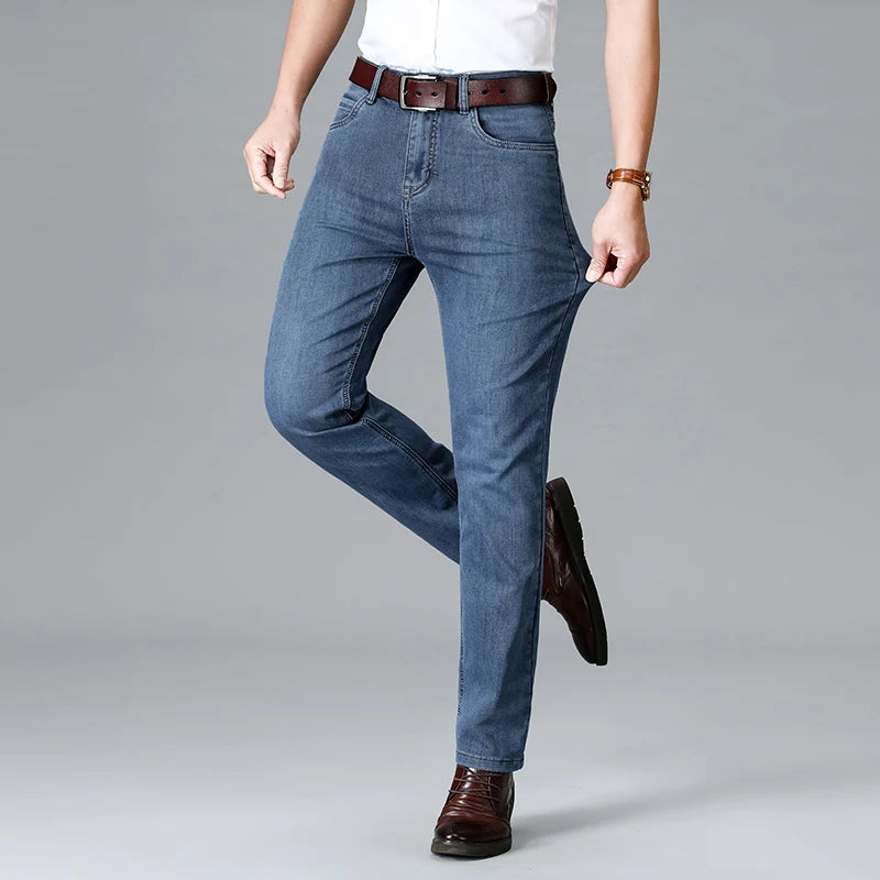 Man wearing light blue stretch slim-fit denim jeans with brown leather belt and dress shoes, casual smart style