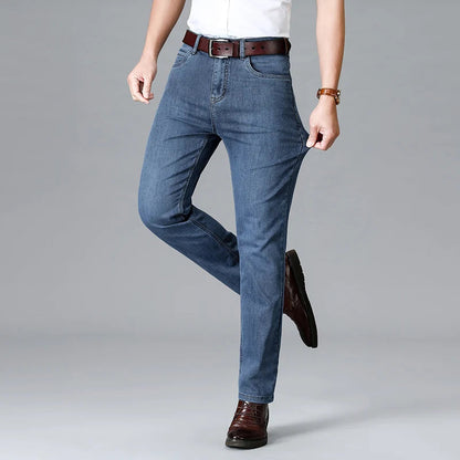 Man wearing light blue stretch slim-fit denim jeans with brown leather belt and dress shoes, casual smart style