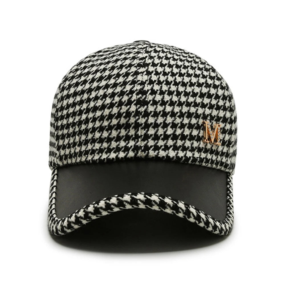 Black and white houndstooth baseball cap with gold M logo and black leather brim, adjustable fit for men