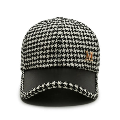 Black and white houndstooth baseball cap with gold M logo and black leather brim, adjustable fit for men