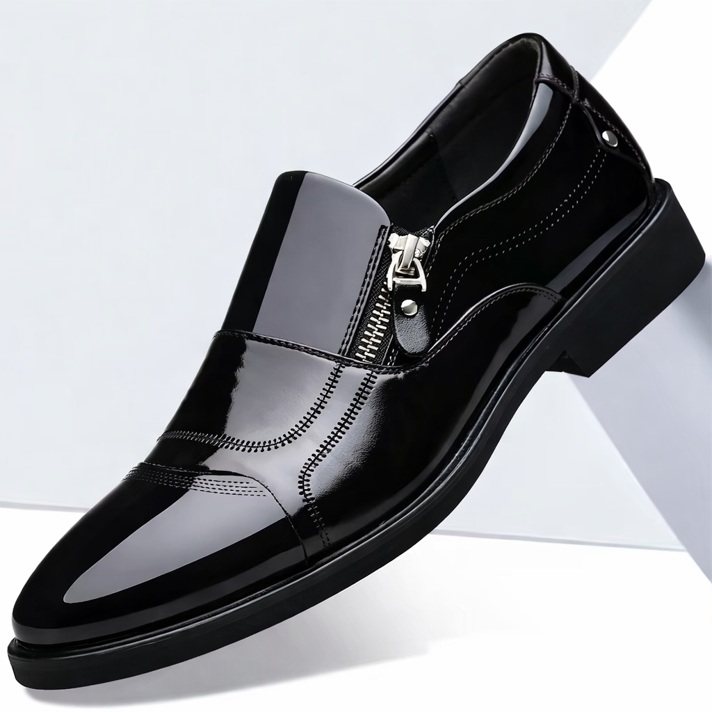 Black patent leather slip-on loafer with silver side zipper, pointed toe, and decorative stitching details.