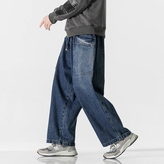 Men's wide-leg denim jeans with relaxed fit, side pockets, and rolled cuffs in dark blue wash