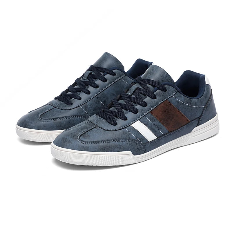Navy blue men's low-top leather sneakers with white stripe, brown panel accent, dark laces, and white sole