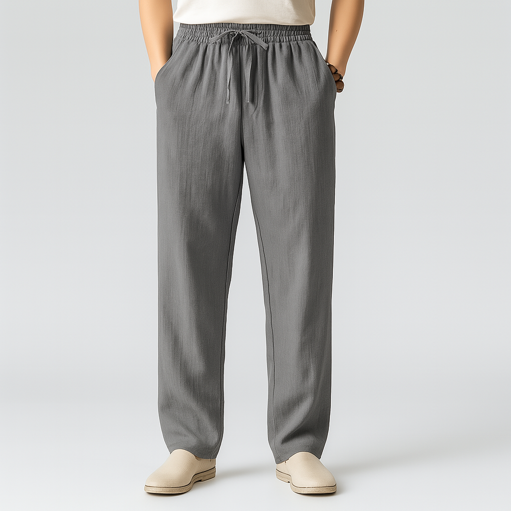 Men's gray linen drawstring pants with elastic waist, side pockets, straight leg fit, paired with beige slip-on shoes.