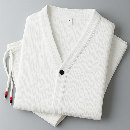 Folded white textured cotton linen men's pajama set with V-neck top, black button, and drawstring pants, size M