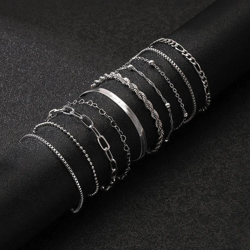 Silver chain bracelet set featuring 10 mixed styles including box, figaro, rope, beaded, and paperclip chains on black background