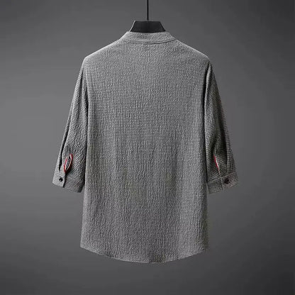 Back view of gray textured cotton linen men's shirt with rose embroidery detail on rolled sleeves, three-quarter length