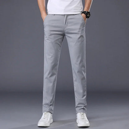Men's slim fit light gray cotton dress pants paired with white sneakers and a white t-shirt, front view.
