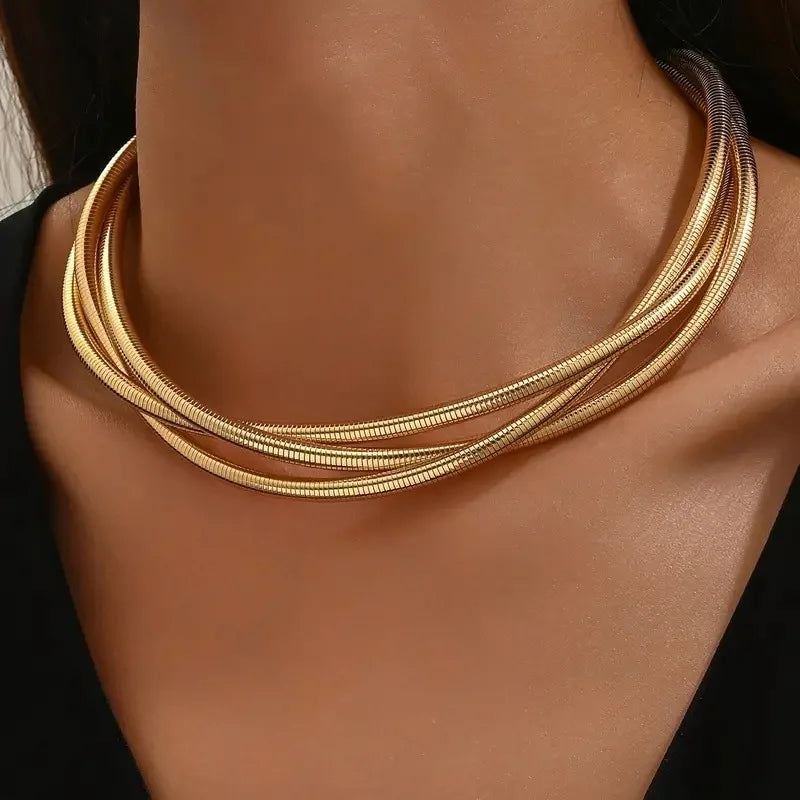 Gold twisted interlock chain necklace for women on model, layered snake chain design, statement jewelry accessory
