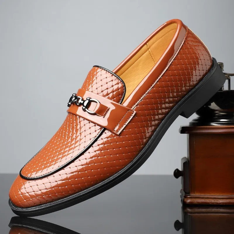 Orange patent leather men's slip-on loafer with woven texture and silver metal horsebit buckle detail, black sole.