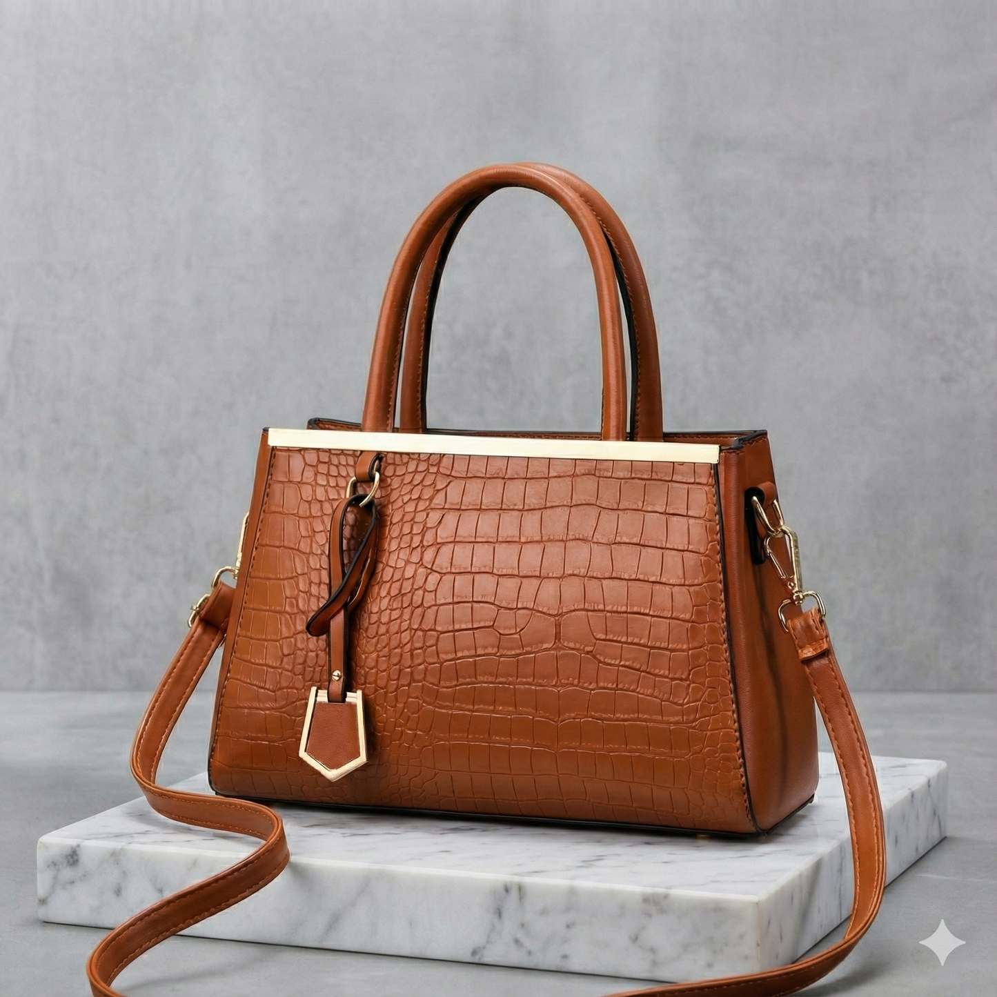 Brown croc-embossed structured handbag with dual top handles, gold-tone hardware, pendant charm, and detachable crossbody strap.
