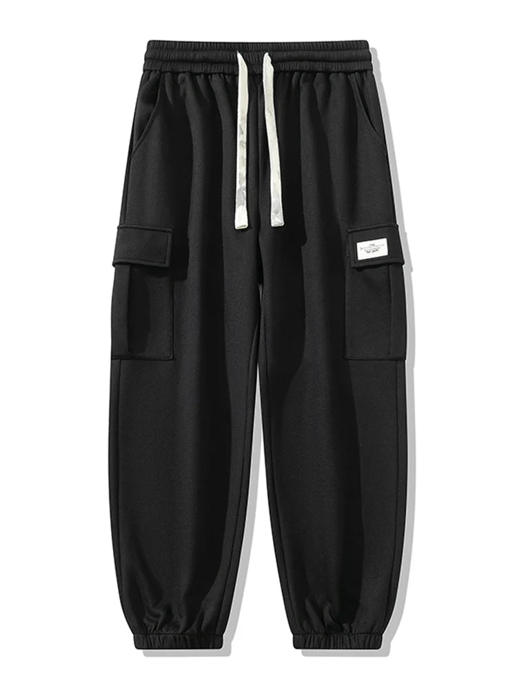 Black men's cargo jogger pants with white drawstring waist, side flap pockets, label patch, and elastic cuffs.