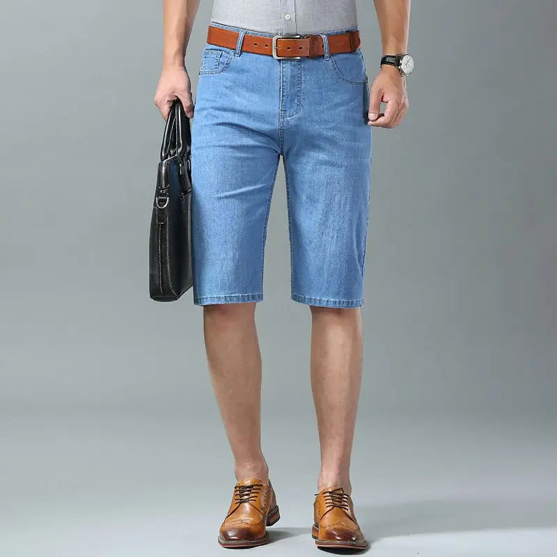 Men's light blue stretch denim shorts with brown leather belt and dress shoes, knee-length casual summer wear
