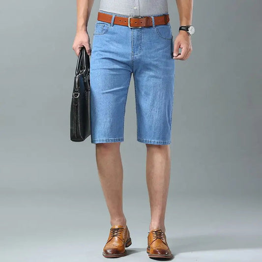 Men's light blue stretch denim shorts with brown leather belt and dress shoes, knee-length casual summer wear