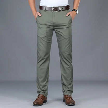 Man wearing slim fit olive green cotton blend dress pants with brown leather belt and dress shoes