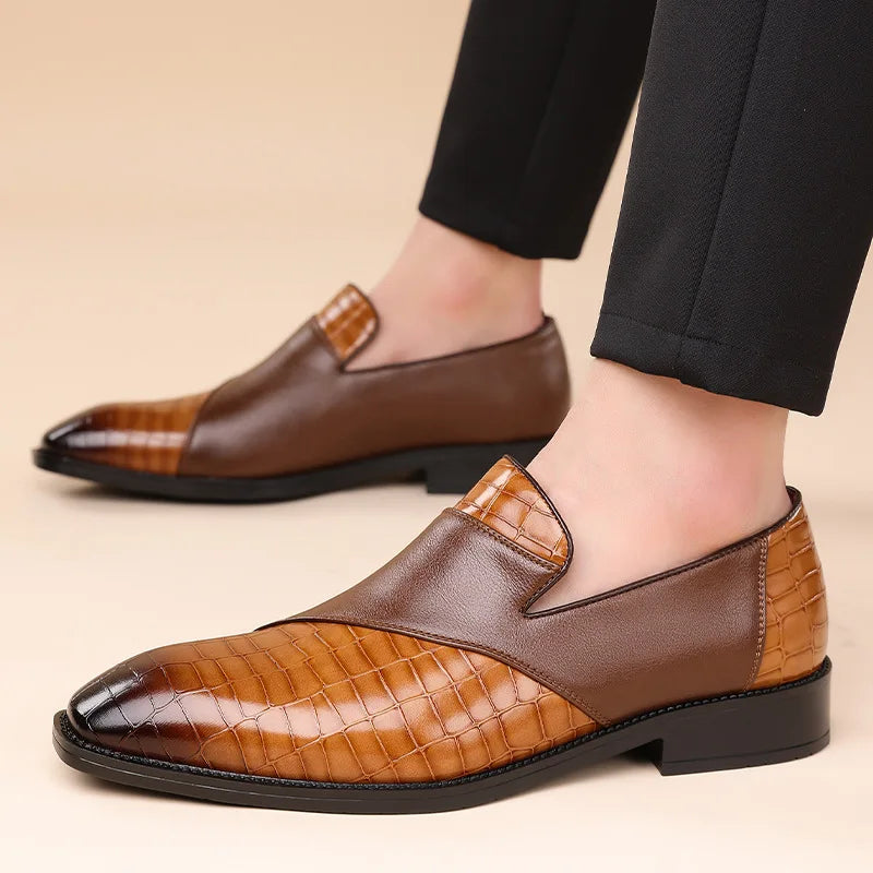 Men's brown leather slip-on loafers with croc-embossed texture and two-tone design, paired with black dress pants.