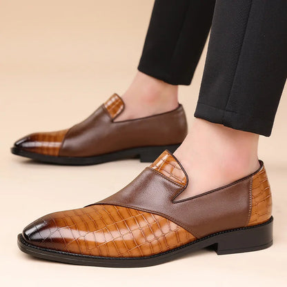 Men's brown leather slip-on loafers with croc-embossed texture and two-tone design, paired with black dress pants.