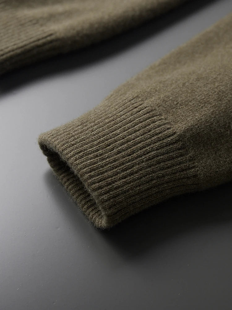 Close-up of olive green merino wool cardigan sleeve cuff showing ribbed knit detail and soft texture