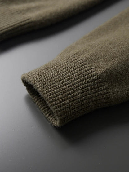 Close-up of olive green merino wool cardigan sleeve cuff showing ribbed knit detail and soft texture