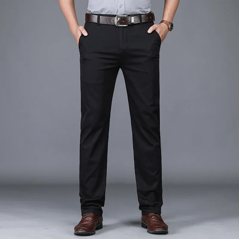 Man wearing slim fit black cotton blend dress pants with brown leather belt and brown dress shoes