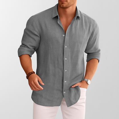 Men's gray linen button-up shirt with rolled sleeves styled with white pants and watch