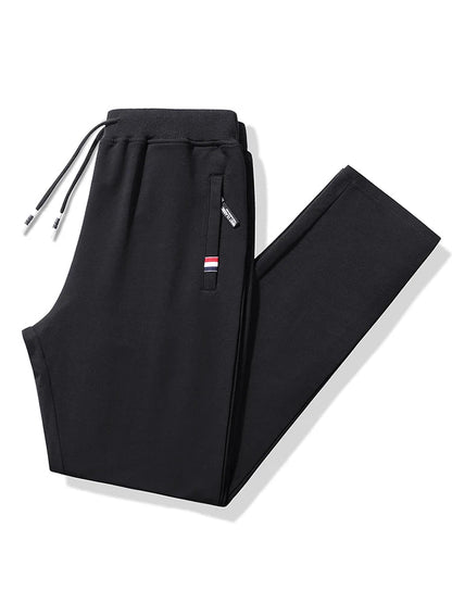 Black men's cotton drawstring sweatpants with elastic waistband, zip pocket, and red-white-blue stripe detail, folded flat.