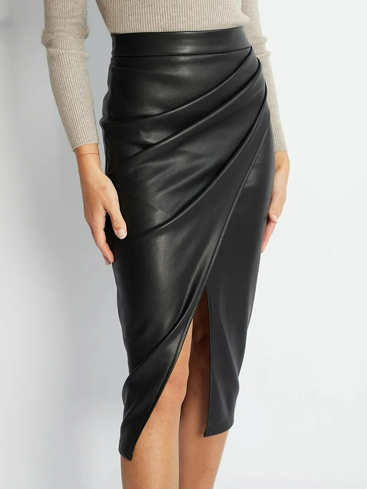 Black vegan leather wrap midi skirt with asymmetric draped detail and side slit paired with beige sweater