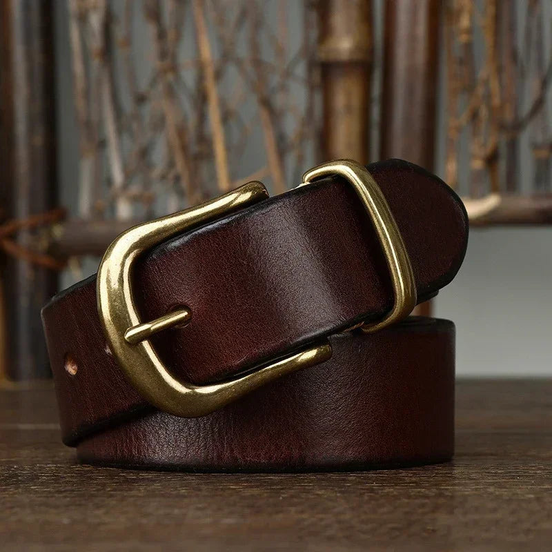 Classic brown leather belt with solid brass buckle for men on rustic wooden surface