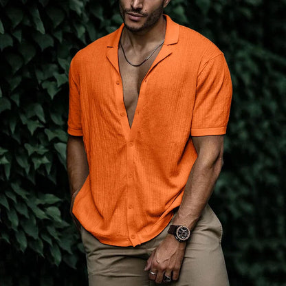 Man wearing orange short sleeve button-down shirt with camp collar, paired with khaki pants and a watch.