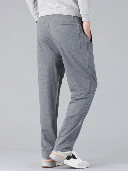 Men's gray cotton drawstring sweatpants with pockets and relaxed fit, rear view